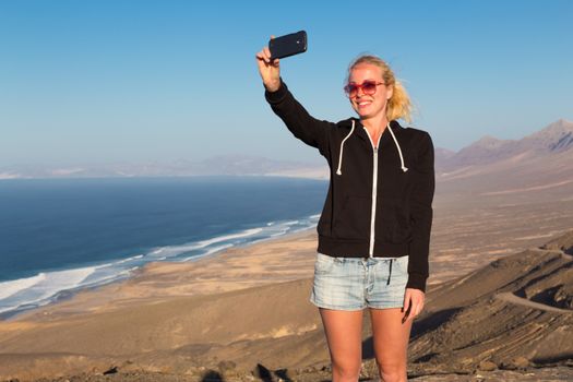Lady taking holiday selfie on El Cofete beach, Fuerteventura, Canary Islands, Spain.