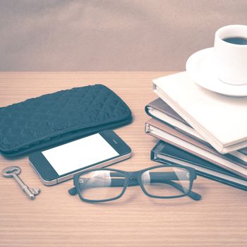 coffee and phone with stack of book,key,eyeglasses and wallet on wood background vintage style