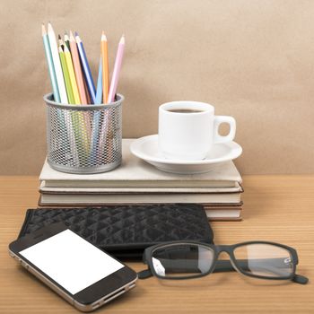 office desk : coffee with phone,stack of book,eyeglasses,wallet,color pencil box on wood background