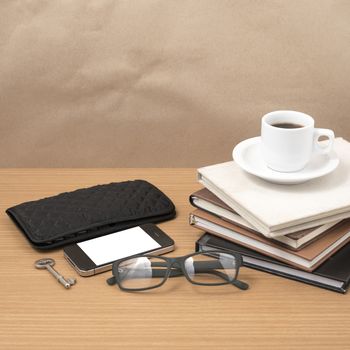 coffee and phone with stack of book,key,eyeglasses and wallet on wood background