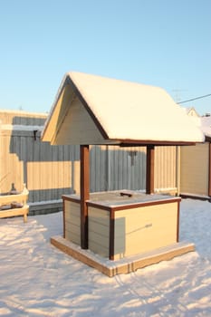 Small house for a well made of wood with shingles, gray and brown