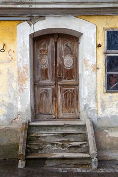 Old door with concrete stairs brown color on the shabby wall background