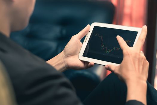 a man checking stock market on tablet, smartphone