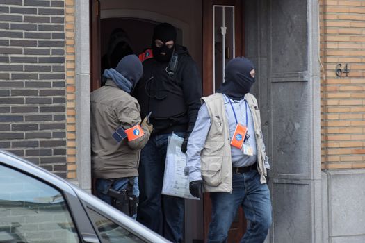 BRUSSELS, Anderlecht: Members of Belgian police make searches at a flat in Anderlecht on March 23, 2016, Belgium. Earlier an arrest was made in connection with the Brussels terrorist attacks. Belgium is observing three days of national mourning after 34 people were killed in a twin suicide blast at Zaventem Airport and a further bomb attack at Maelbeek Metro Station. Two brothers are thought to have carried out the airport attack and an international manhunt is underway for a third suspect. The attacks come just days after a key suspect in the Paris attacks, Salah Abdeslam, was captured in Brussels.