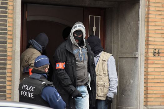BRUSSELS, Anderlecht: Members of Belgian police make searches at a flat in Anderlecht on March 23, 2016, Belgium. Earlier an arrest was made in connection with the Brussels terrorist attacks. Belgium is observing three days of national mourning after 34 people were killed in a twin suicide blast at Zaventem Airport and a further bomb attack at Maelbeek Metro Station. Two brothers are thought to have carried out the airport attack and an international manhunt is underway for a third suspect. The attacks come just days after a key suspect in the Paris attacks, Salah Abdeslam, was captured in Brussels.
