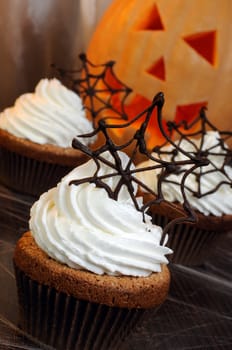 Muffin with whipped cream and chocolate cobwebs for Halloween