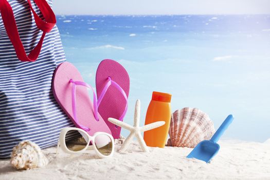 sandy beach with summer accessories and copy space around objects