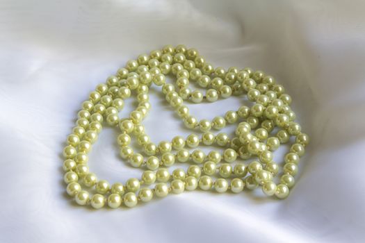 Pearl necklace on a White silk