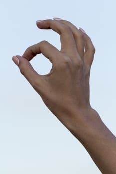 girl's hand against the blue sky