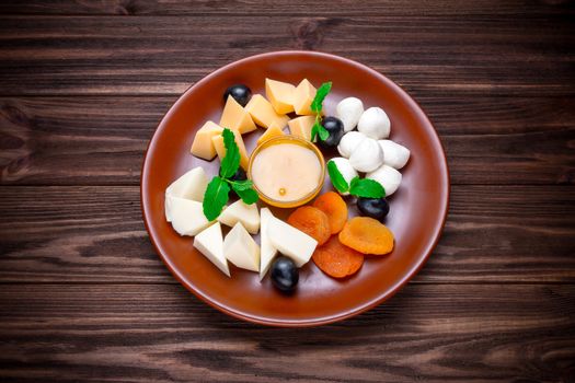 Assortment of some cheese on wooden background with honey  