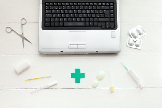 Portable and instrumental retro medical computer on white wooden background