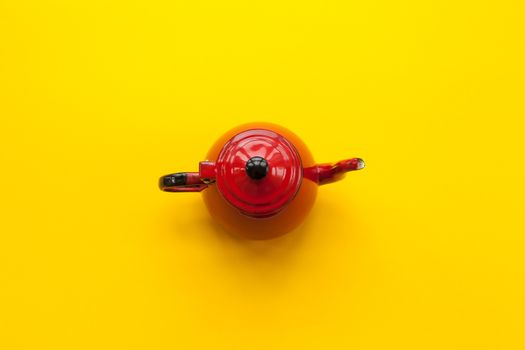 Red teapot on solid yellow background very colorful and contrasted