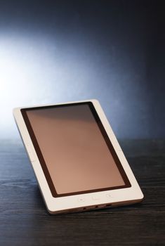 One modern tablet with blank screen on nice dark background