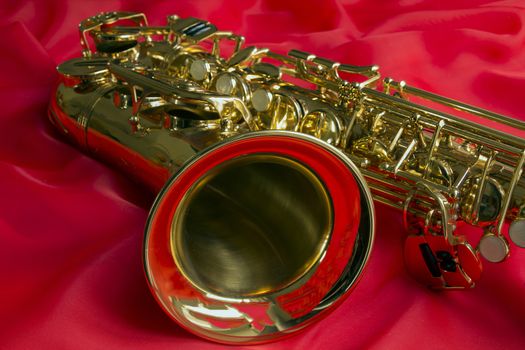 beautiful golden saxophone on delicate red silk background