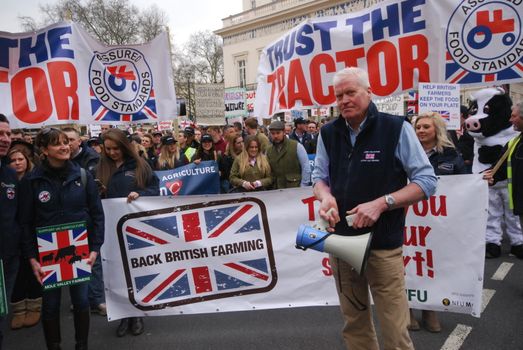 UNITED KINGDOM, London: Protesters stand behind a banner which reads Back British Farming during a demonstration of English farmers to British Prime Minister office in Downing Street in London on March 23, 2016 to protest against the low cost prices of agricultural product.