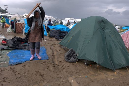 GREECE, Idomeni: A woman is about to walk in mud as thousands of migrants are stranded in a makeshift camp for migrants and refugees at the Greek-Macedonian border near the village of Idomeni on March 23, 2016. The UN refugee agency harshly criticized an EU-Turkey deal on curbing the influx of migrants to Greece, saying reception centers had become detention facilities, and suspended some activities in the country. The EU and Ankara struck a deal aiming to cut off the sea crossing from Turkey to the Greek islands that enabled 850,000 people to pour into Europe last year, many of them fleeing the brutal war in Syria.