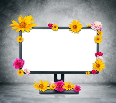 Monitor with flowers on grey wall background
