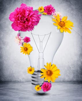 Bulb with flowers on grey wall background