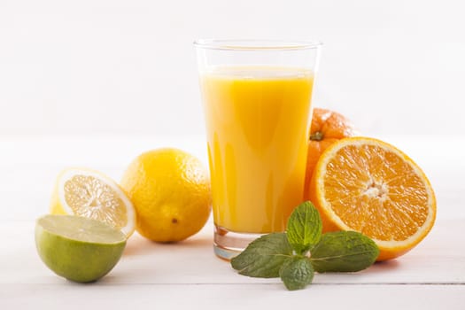 Healthy and fresh mixed juice from fruits on white wooden table