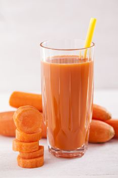 Tasty fresh carrot drink from carrots on wooden table, studio shot