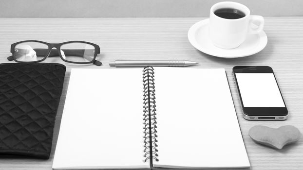 office desk : coffee with phone,notepad,eyeglasses,wallet,heart on wood background black and white color