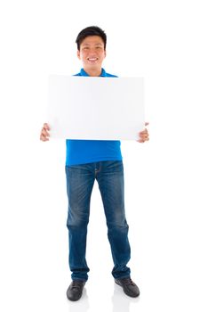 Asian businessman holding a blank card board with copy space, standing on plain background.