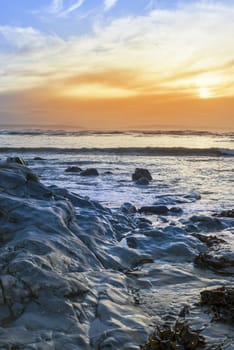 reflections at rocky beach near ballybunion on the wild atlantic way ireland with a beautiful yellow sunset