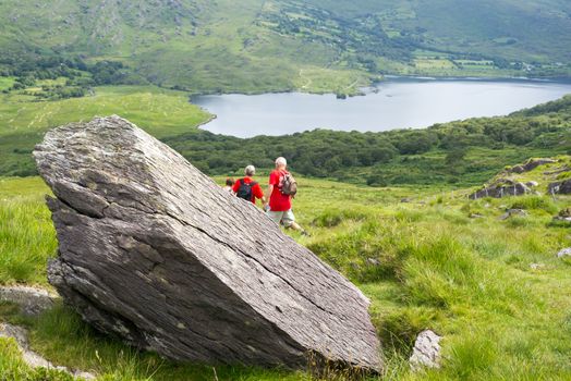 big rock with hikers on the kerry way in irelands wild atlantic way