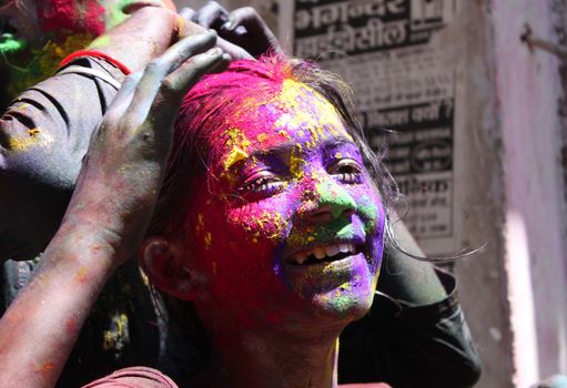 INDIA, Allahabad: A child wears vibrantly colored paints during Holi celebrations in Allahabad, India on March 24, 2016. Hindu devotees splatter each other with paint during Holi celebrations to mark the advent of spring. It is celebrated across the country and in many other countries in the region.