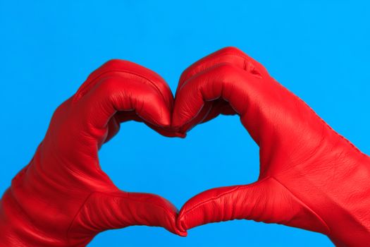 two hands with red leather hands forming a heart