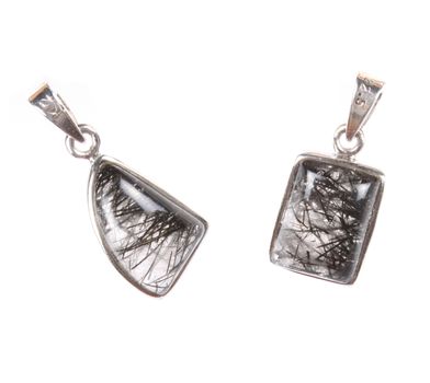 A pair of pendants made of silver and semi precious gemstones, on white studio background