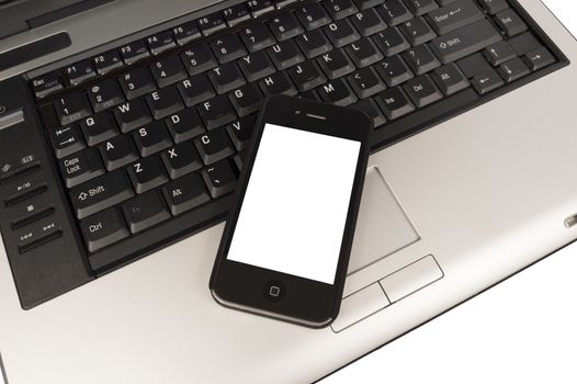 Over head view of business phone with blank screen for your copy resting on keyboard of laptop.