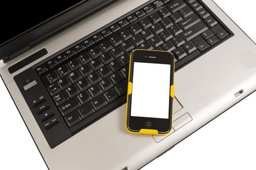 Mobile smart phone on a laptop computer keyboard.  Isolated on white.