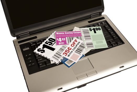 Please note that coupons are not real.  Opened laptop computer with scattered coupons with the concept of getting coupons online.