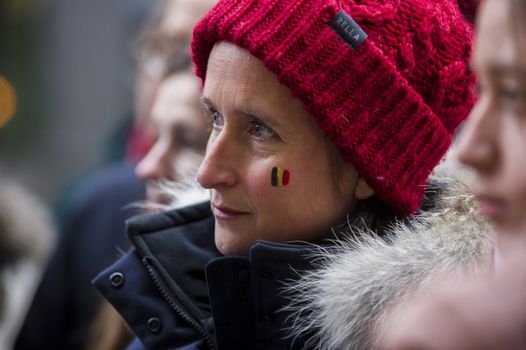CANADA, Montreal: A woman's face bears the Belgian flag at a vigil in Montreal, Canada on March 23, 2016 for the victims of the attacks in Brussels that killed at least 30 people and injured hundreds of others the day before. Responsibility for the bombings at Zavetum airport and Molenbeek metro station was later taken by the Islamic State terror group.