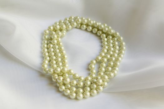 Pearl necklace on a White silk