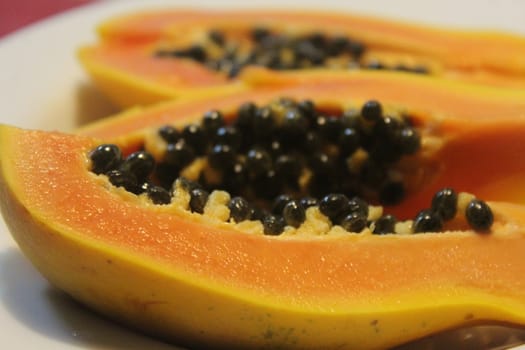 Papaya on white plate, on the wooden table.