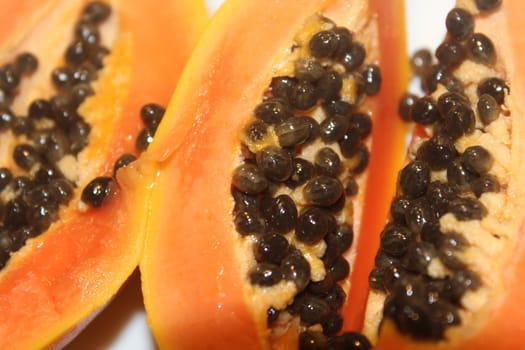 Papaya on white plate, on the wooden table.