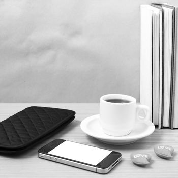 office desk : coffee with phone,heart,stack of book,wallet on wood background black and white color