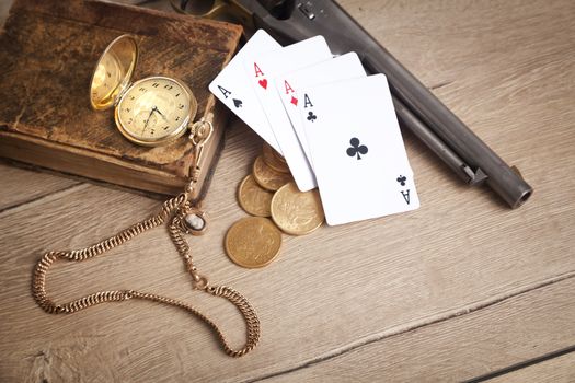 gambling and crime concept with gun, cards and golden coins