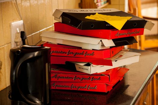 Stacked empty pizza boxes after a feast