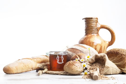 Freshly baked bread,honey and eggs on wooden vintage table