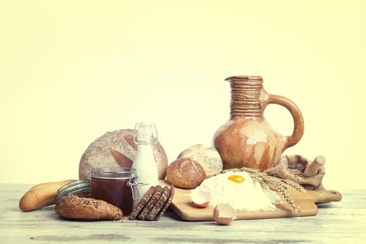 Freshly baked bread,honey and eggs on wooden vintage table