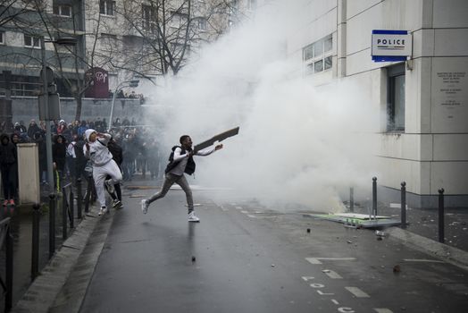 FRANCE, Paris: A young man throws projectiles against the police station of Paris 19th arrondissement, on March 25, 2016, in a sign of protest against alledged police violence on a student during a demonstration of youths against the French labour law reform.A video of a policeman punching a student went viral on social media on March 24, and an enquiry has been opened into the incident. Tens of thousands of students protesting labour reforms took to the streets across France on March 24, torching cars in Paris and clashing with riot police who responded with tear gas and made more than 30 arrests.