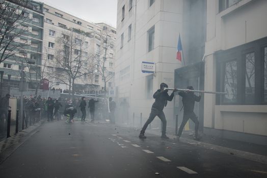 FRANCE, Paris: Young people throw projectiles against the police station of Paris 19th arrondissement, on March 25, 2016, in a sign of protest against alledged police violence on a student during a demonstration of youths against the French labour law reform.A video of a policeman punching a student went viral on social media on March 24, and an enquiry has been opened into the incident. Tens of thousands of students protesting labour reforms took to the streets across France on March 24, torching cars in Paris and clashing with riot police who responded with tear gas and made more than 30 arrests.