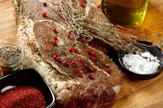 Perfect Big Raw Beef Steak with Spices and Herbs Ready to Roast closeup on Wooden background