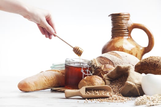 Freshly baked bread,honey and eggs on wooden vintage table