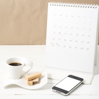 coffee cup with wafer,phone,calendar on white wood background