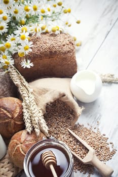 Freshly baked bread rolls, wheat ears and honey