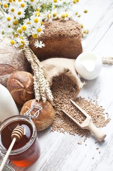 Freshly baked bread rolls, wheat ears and honey